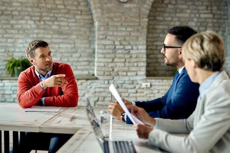 Besprechung von vier Personen an einem Tisch im Büro