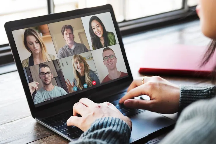 Laptop mit Videokonferenz und mehreren Teilnehmenden