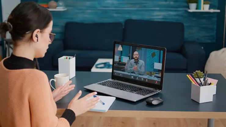 Frau im Videogespräch mit einem Dozenten am Laptop