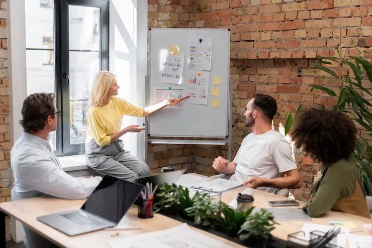 Team bespricht Ergebnisse an einem Whiteboard im Büro